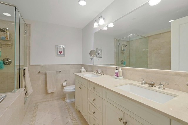 full bath with a stall shower, a sink, and tile patterned floors