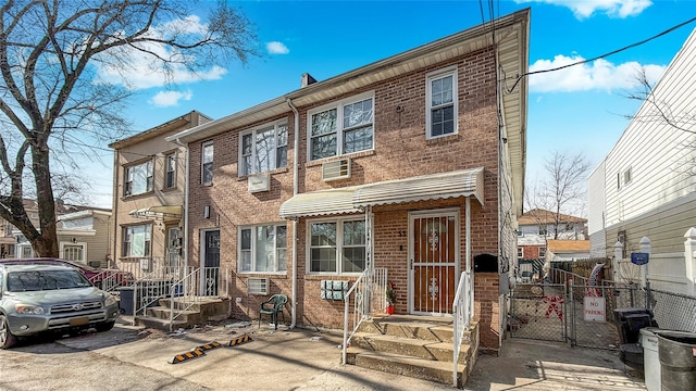 view of property featuring brick siding and fence