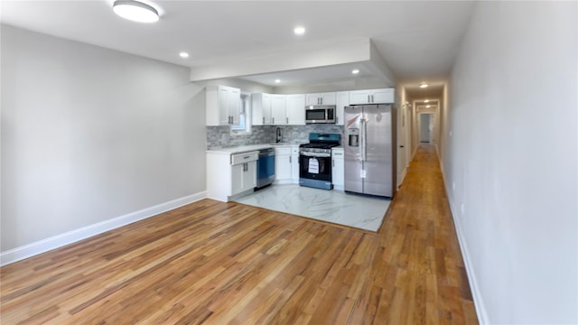 kitchen with stainless steel appliances, baseboards, white cabinets, light countertops, and tasteful backsplash