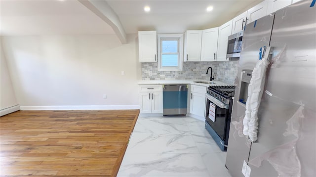 kitchen with white cabinets, backsplash, marble finish floor, stainless steel appliances, and a sink