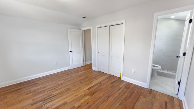 unfurnished bedroom with light wood finished floors, a closet, and baseboards