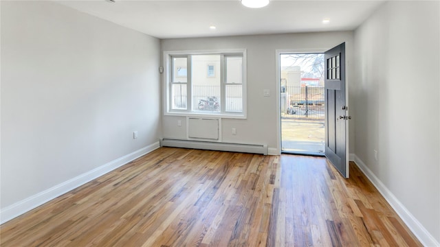 doorway to outside featuring a baseboard heating unit, recessed lighting, baseboards, and light wood finished floors