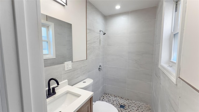 full bath with plenty of natural light, a shower stall, toilet, and vanity