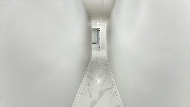 hall with marble finish floor and baseboards