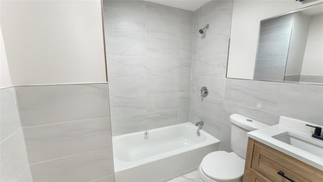 bathroom with shower / bathtub combination, toilet, vanity, tile walls, and marble finish floor