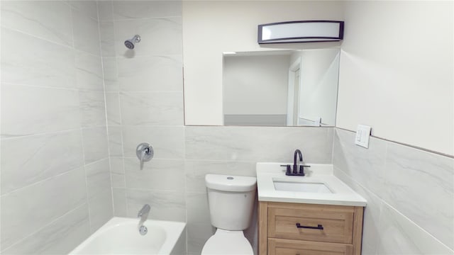 bathroom featuring toilet, shower / bathing tub combination, tile walls, and vanity