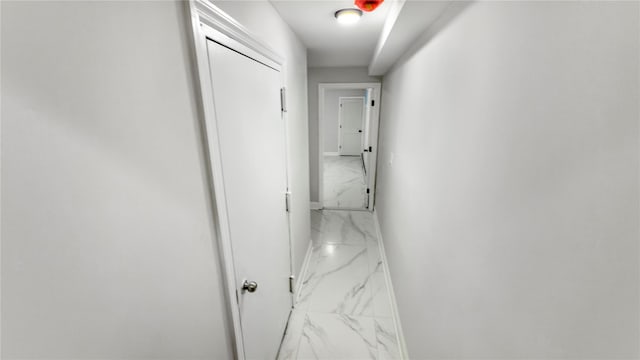 hall with marble finish floor and baseboards