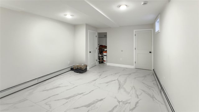 spare room featuring a baseboard heating unit, marble finish floor, and baseboards