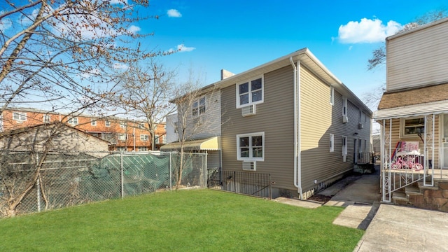 back of house featuring a lawn and fence