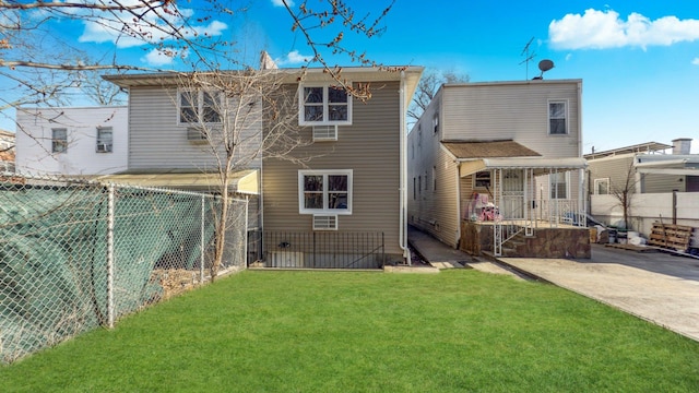 rear view of property with a fenced backyard and a yard