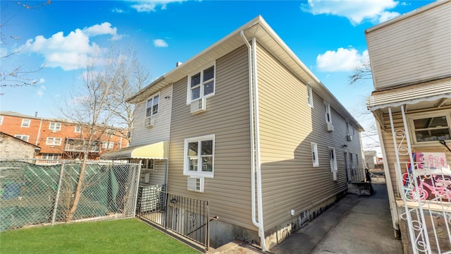 view of side of property with a lawn and fence