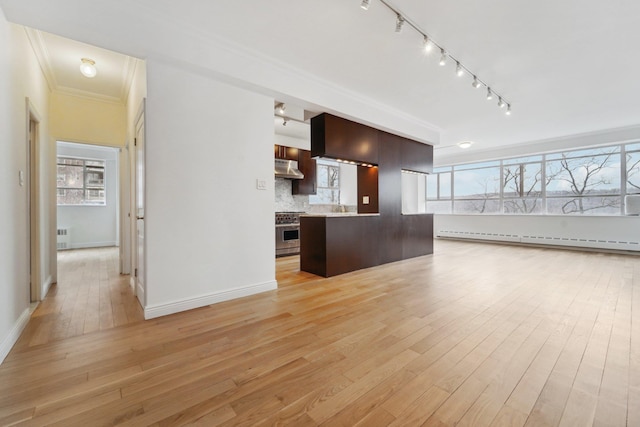 2727 Palisade Ave Unit 4H, Bronx, NY 10463 - kitchen with stainless steel range, track lighting, under cabinet range hood, dark brown cabinetry, and light wood-style floors