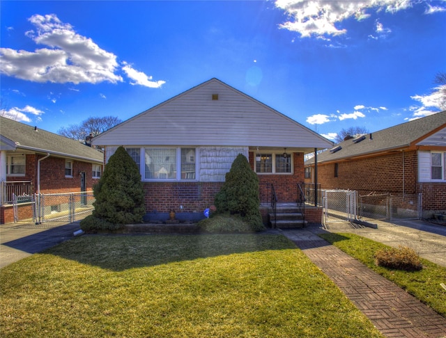 bungalow with brick siding, a front yard, fence, and a gate