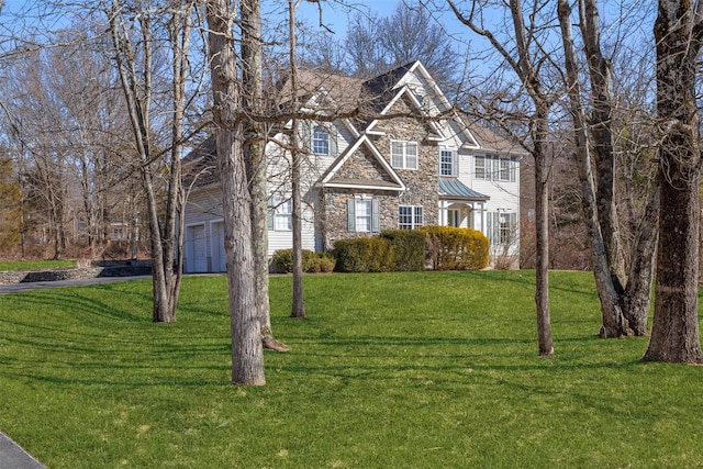 view of front facade with stone siding, metal roof, a front lawn, and a standing seam roof