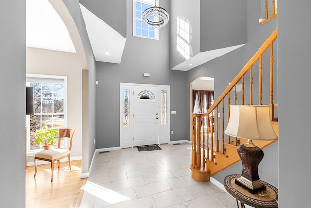 entrance foyer with a healthy amount of sunlight, stairway, and baseboards