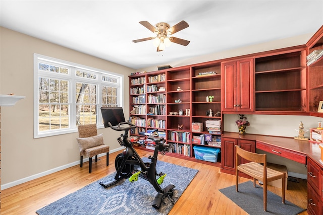 office space with a ceiling fan, baseboards, and light wood finished floors