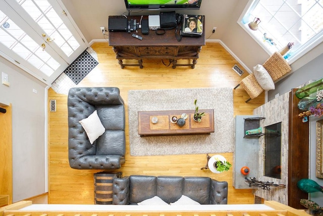 living area with wood finished floors, visible vents, and baseboards