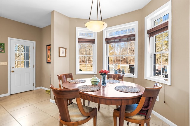 dining space featuring light tile patterned flooring and baseboards