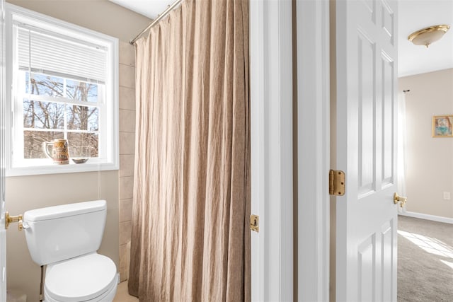 full bathroom with a shower with shower curtain, toilet, and baseboards