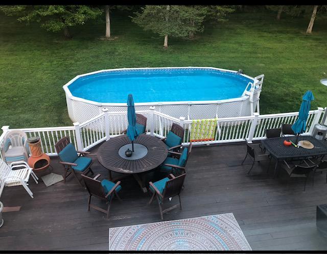 outdoor pool featuring outdoor dining space and a deck