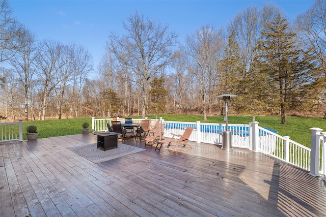 wooden terrace featuring outdoor dining area, a lawn, and an outdoor pool