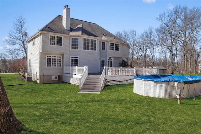 rear view of property with a fenced in pool, central AC, a lawn, and a wooden deck