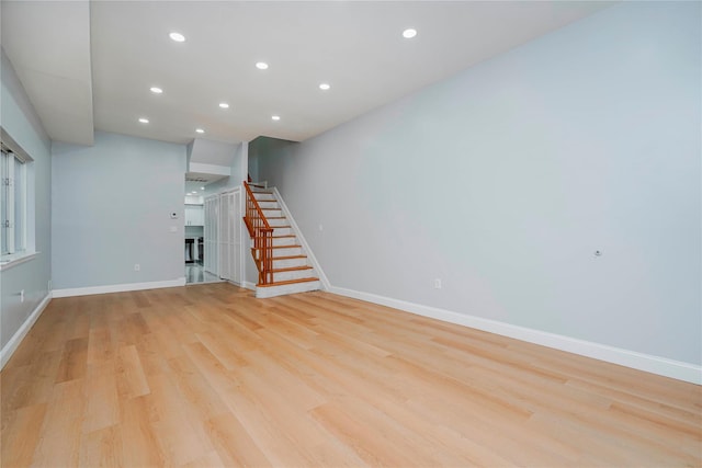 interior space with recessed lighting, baseboards, light wood finished floors, and stairs