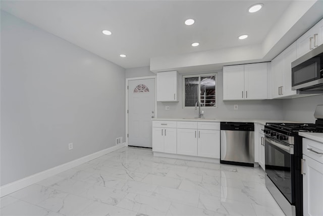 kitchen with baseboards, marble finish floor, stainless steel appliances, light countertops, and a sink