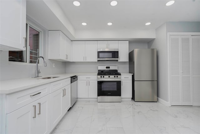 kitchen featuring stainless steel appliances, recessed lighting, marble finish floor, and a sink