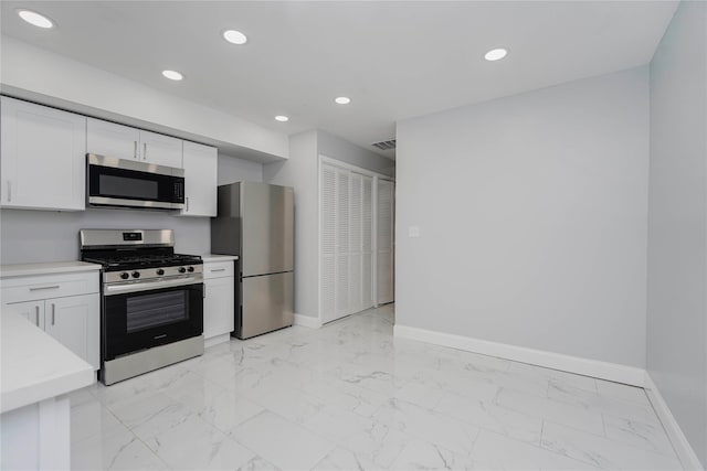 kitchen with stainless steel appliances, visible vents, baseboards, and white cabinetry