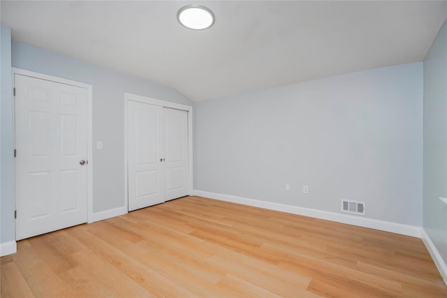 unfurnished bedroom featuring a closet, visible vents, light wood-style flooring, and baseboards