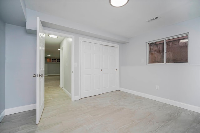 unfurnished bedroom featuring baseboards, visible vents, and a closet