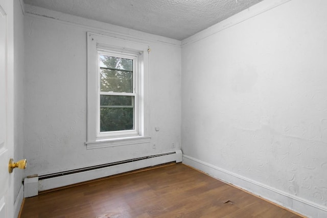 unfurnished room with a baseboard heating unit, a textured wall, a textured ceiling, and wood finished floors