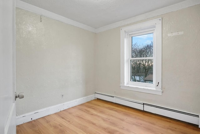 spare room featuring a baseboard radiator, a textured wall, a textured ceiling, and wood finished floors