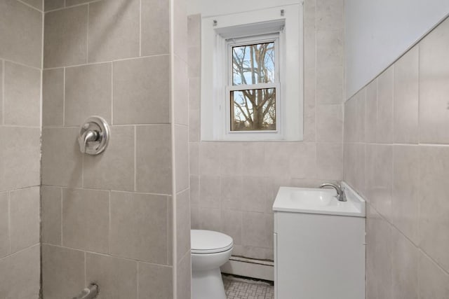 bathroom with tile walls, toilet, baseboard heating, vanity, and tile patterned floors