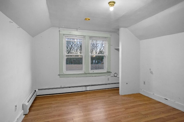 additional living space featuring vaulted ceiling, baseboard heating, and wood finished floors