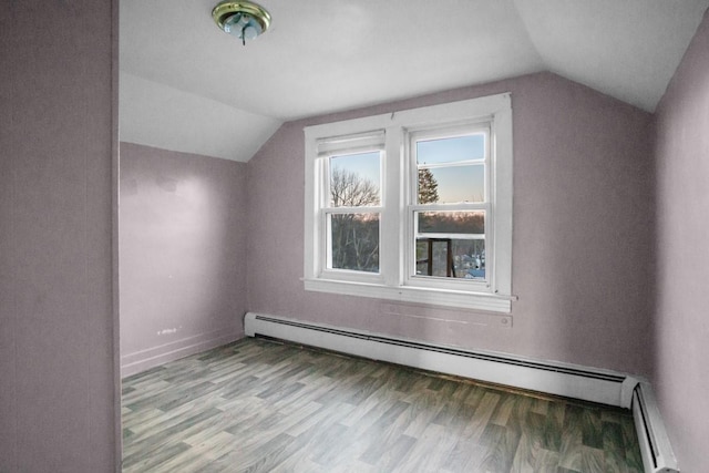 additional living space featuring vaulted ceiling, a baseboard radiator, and wood finished floors