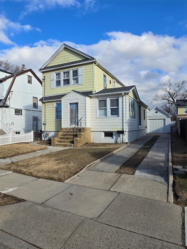 view of front of house featuring entry steps, an outdoor structure, driveway, and fence