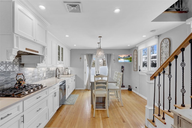 kitchen with a healthy amount of sunlight, visible vents, stainless steel appliances, and white cabinets