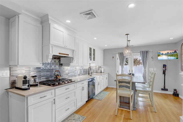 kitchen with stainless steel appliances, visible vents, light wood-style floors, and white cabinetry