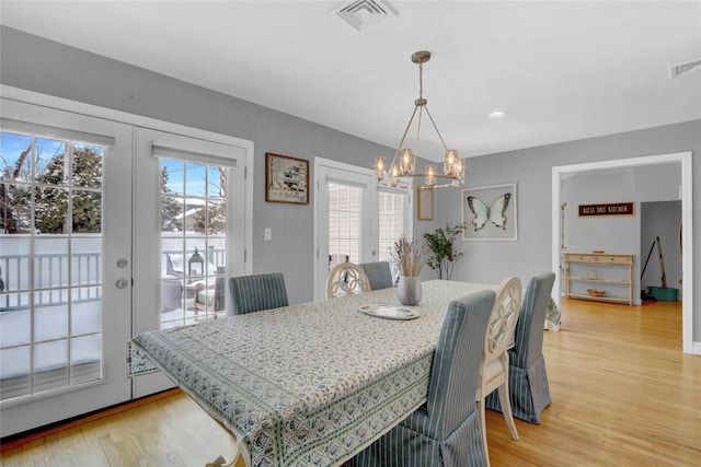 dining area featuring french doors, plenty of natural light, visible vents, and light wood-style floors