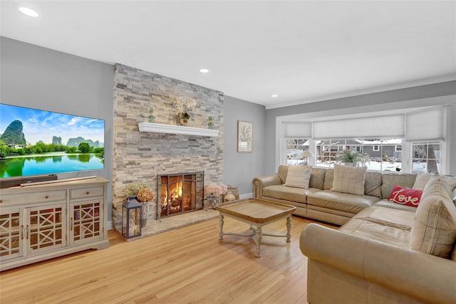 living room featuring recessed lighting, a healthy amount of sunlight, a fireplace, and wood finished floors