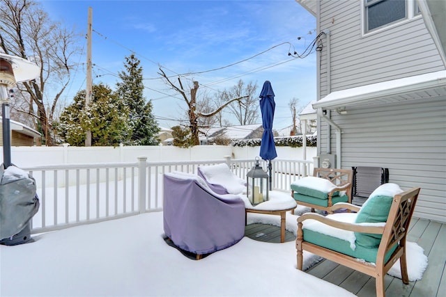 snow covered deck featuring a fenced backyard