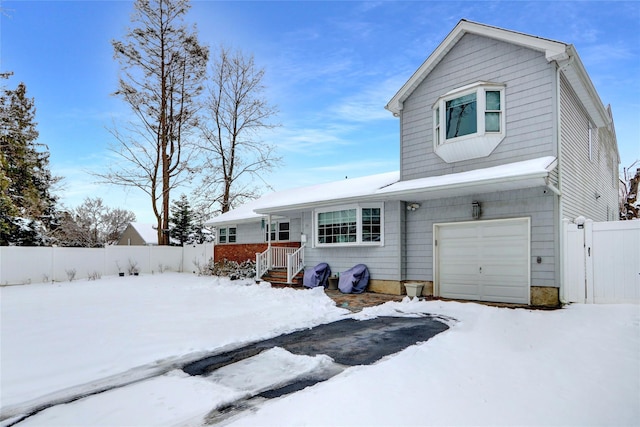 view of front of property featuring a garage, a gate, and fence