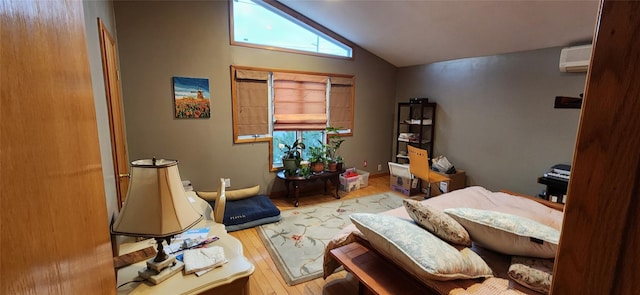 bedroom featuring lofted ceiling, a wall unit AC, and wood finished floors