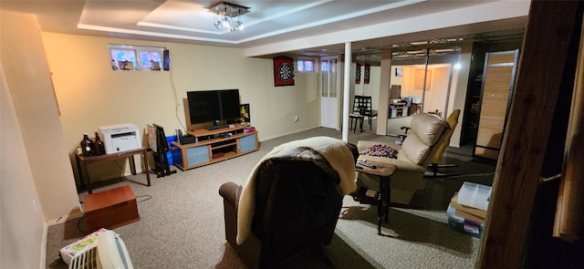 carpeted living room with a raised ceiling and baseboards