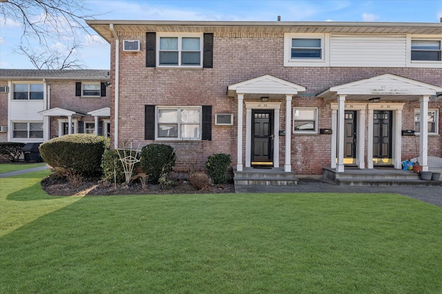 multi unit property featuring brick siding and a front lawn