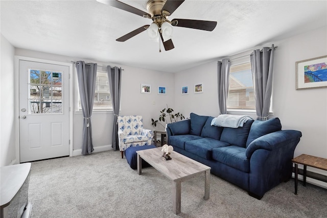 carpeted living area with ceiling fan, plenty of natural light, a baseboard radiator, and baseboards