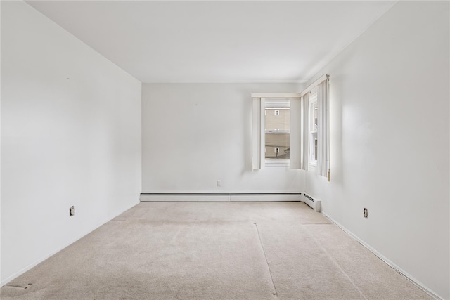 carpeted spare room with a baseboard heating unit