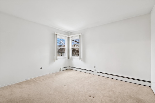 empty room featuring a baseboard heating unit and carpet flooring